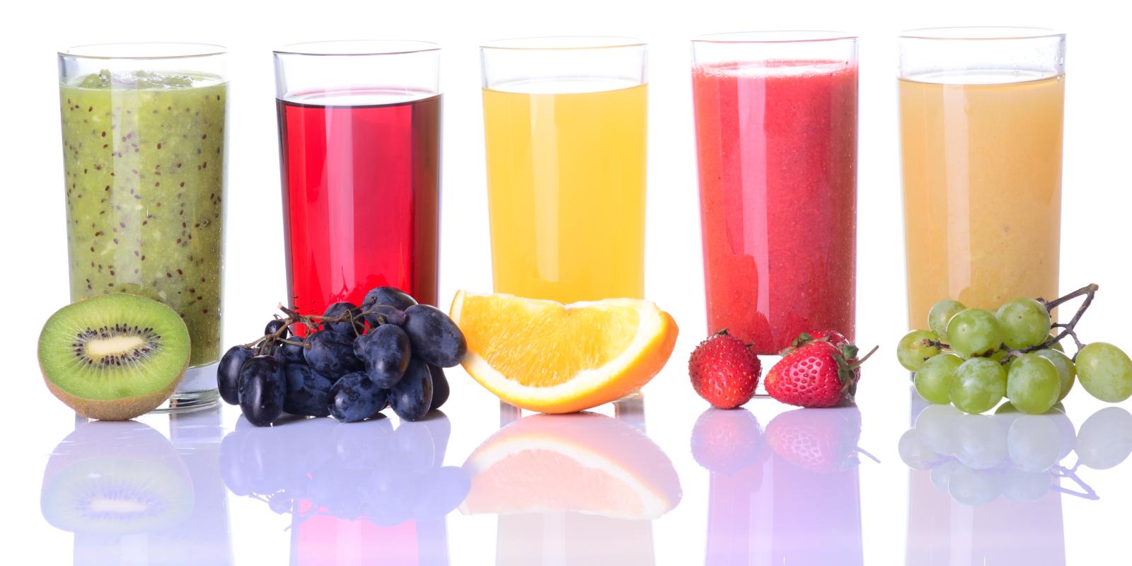 Fem glass med fruktjus, kiwi, blå druer, appelsin, jordbær og grønne druer.